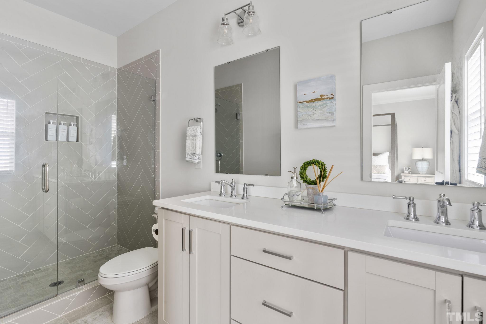 1610 Draper View Loop, Unit 104 Raleigh, NC 27608 - Photo 27 of 41 a bathroom with a granite countertop toilet sink and mirror