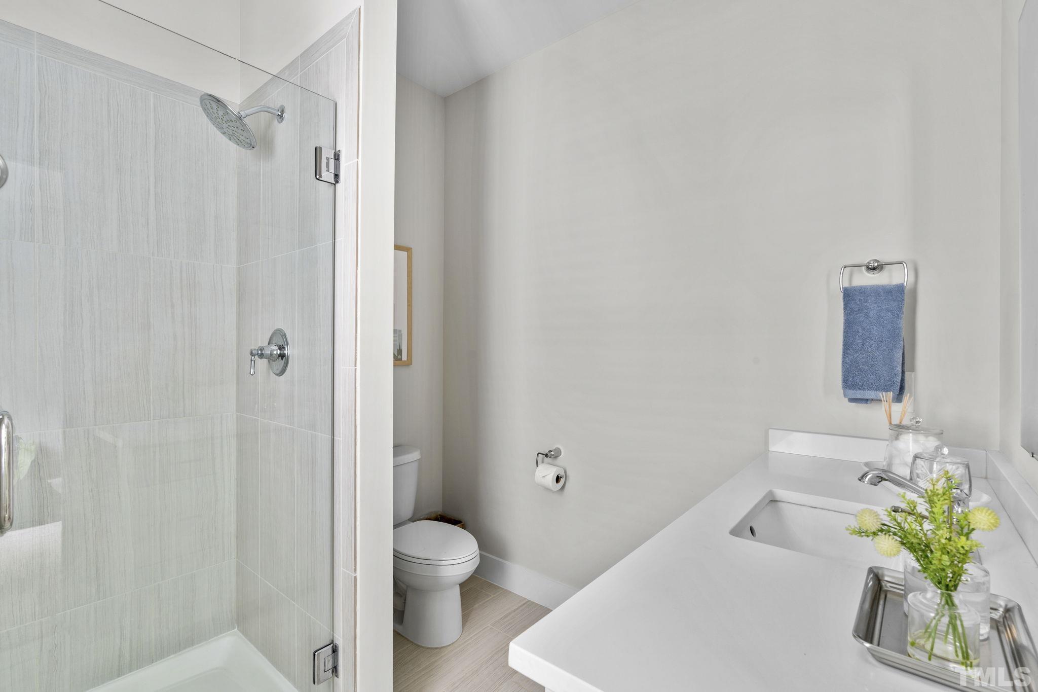 1610 Draper View Loop, Unit 104 Raleigh, NC 27608 - Photo 30 of 41 a bathroom with a sink a toilet and shower