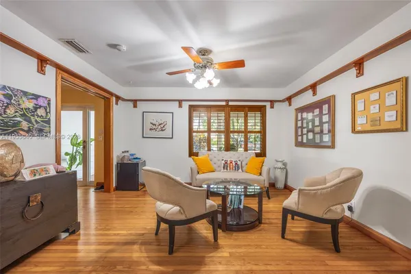 a dining room with furniture a chandelier and wooden floor
