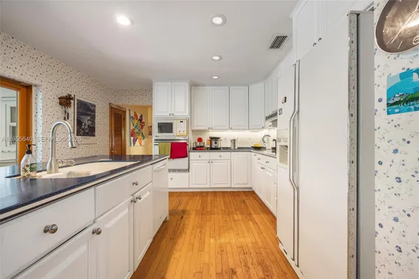 a kitchen with cabinets a sink and appliances