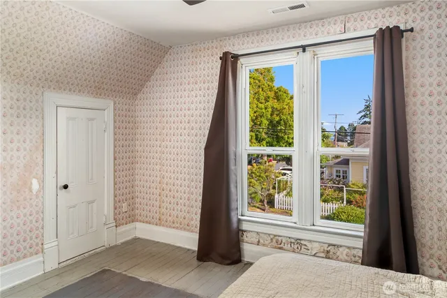 a bedroom with a bed and a large window