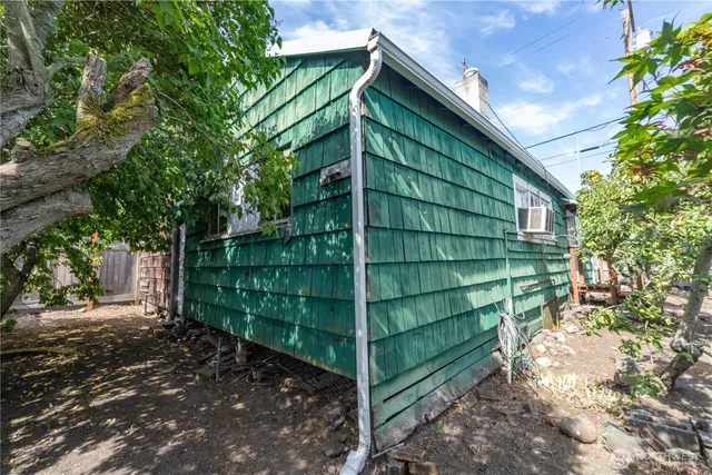 a view of backyard with table and chairs and wooden fence