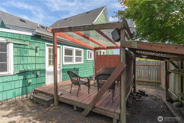 a view of backyard with deck and outdoor seating