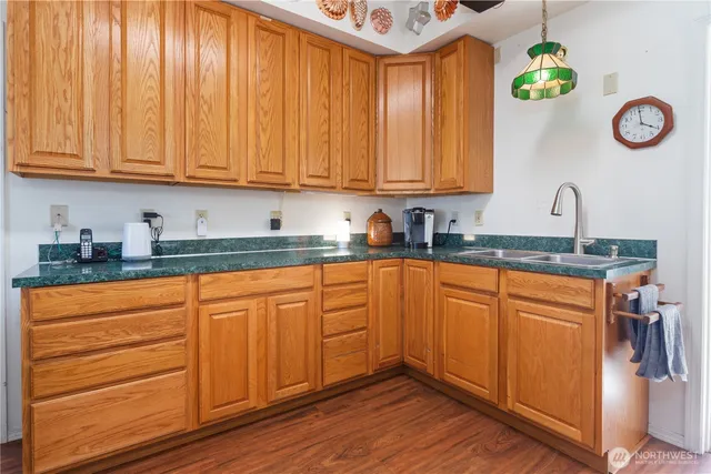 a kitchen with stainless steel appliances granite countertop wooden cabinets a stove a sink and a window