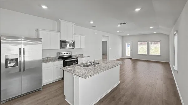 a kitchen with granite countertop kitchen island wooden floors appliances and center island