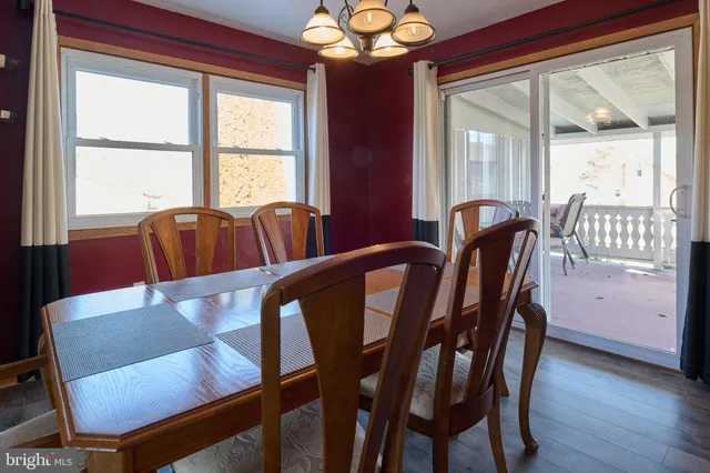 a view of a dining room with furniture a chandelier and wooden floor