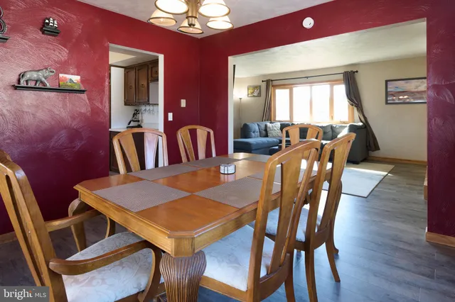 a view of a dining room with furniture a chandelier and wooden floor