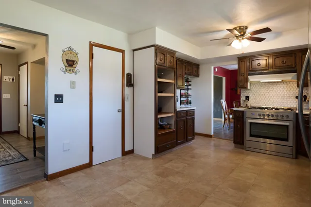 a view of a livingroom with a ceiling fan closet and windows