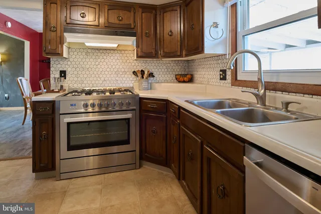 a kitchen with stainless steel appliances granite countertop a stove and a sink