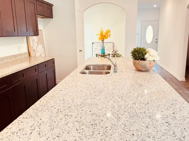 a kitchen with a sink a counter and a view of living room