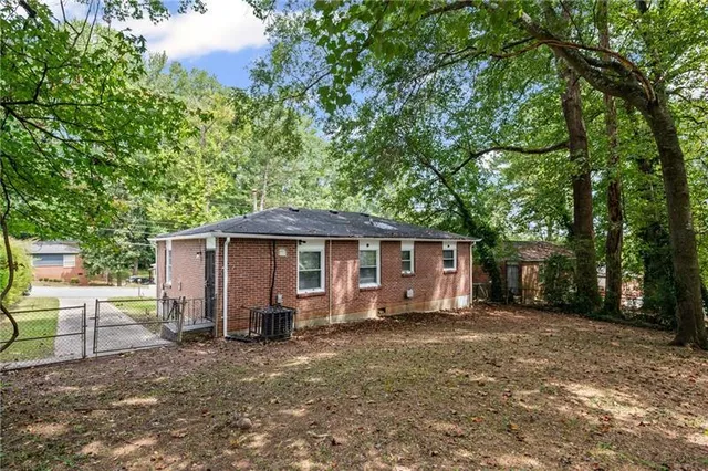 a view of a house with a yard and large tree