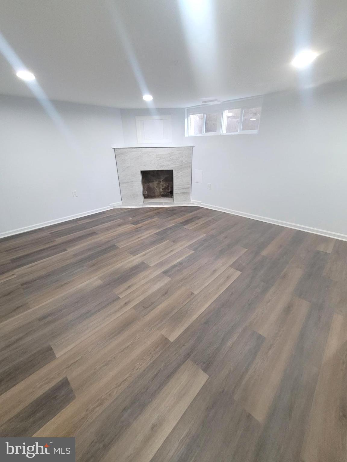 4603 Marble Hall Road Baltimore, MD 21239 - Photo 15 of 24 an empty room with wooden floor and fireplace