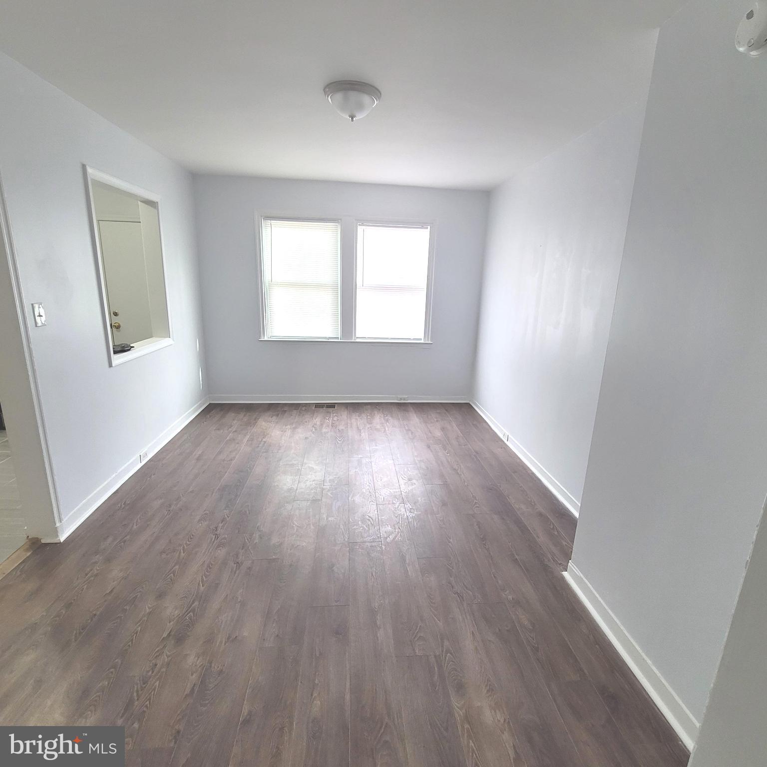 4603 Marble Hall Road Baltimore, MD 21239 - Photo 4 of 24 an empty room with wooden floor and windows