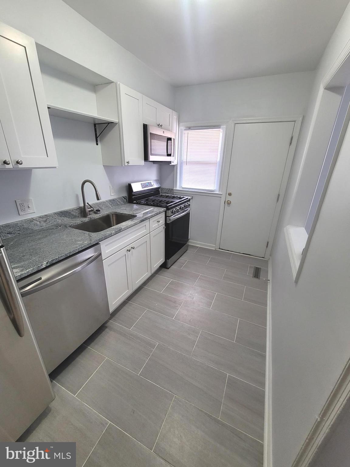 4603 Marble Hall Road Baltimore, MD 21239 - Photo 7 of 24 a large kitchen with stainless steel appliances granite countertop a sink and cabinets