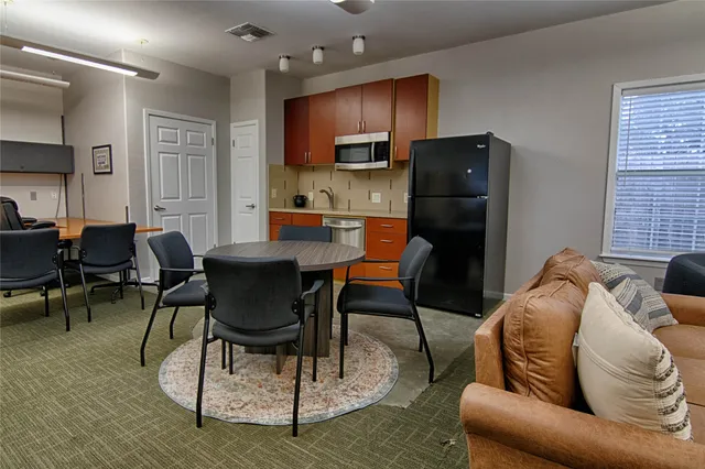 a living room with furniture a wooden floor and kitchen view