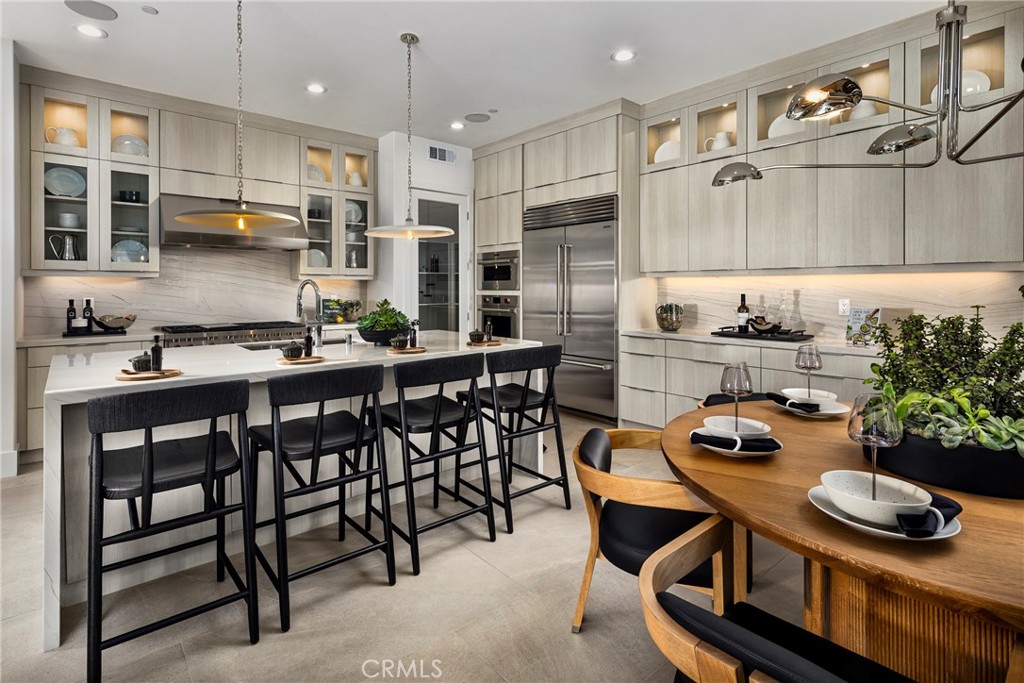 136 Creation Irvine, CA 92618 - Photo 4 of 18 a kitchen with stainless steel appliances a table and chairs in it