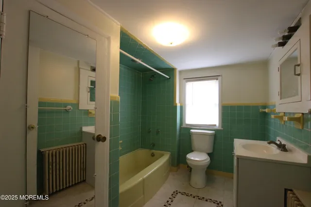a bathroom with a toilet sink and mirror