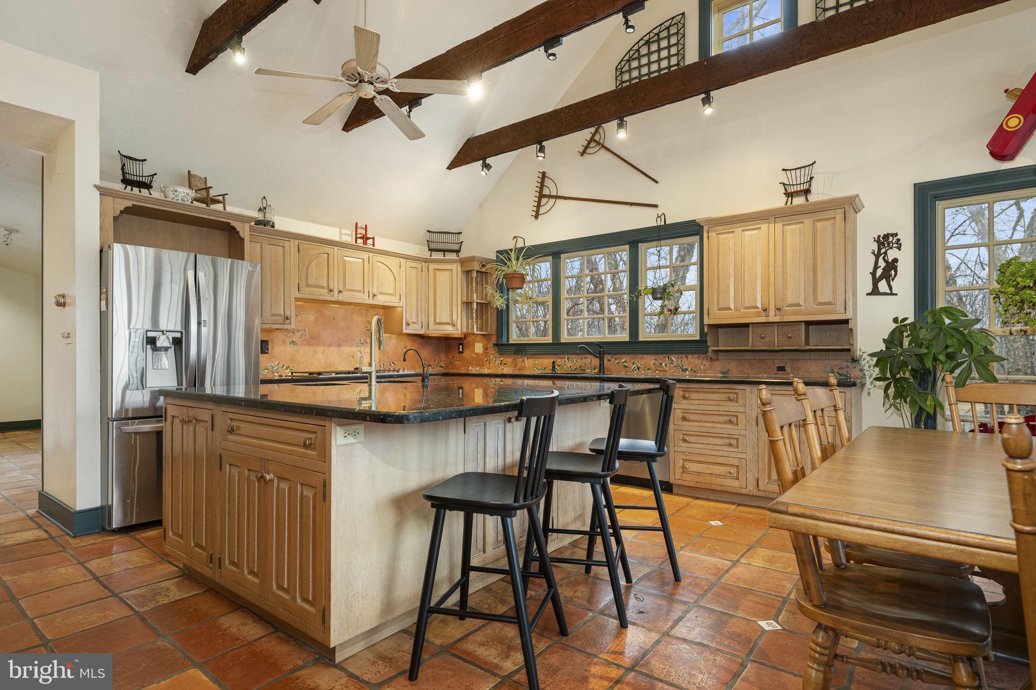 371 Old Tulpehocken Road Birdsboro, PA 19508 - Photo 18 of 99 a kitchen with stainless steel appliances kitchen island granite countertop a table chairs in it and wooden floors