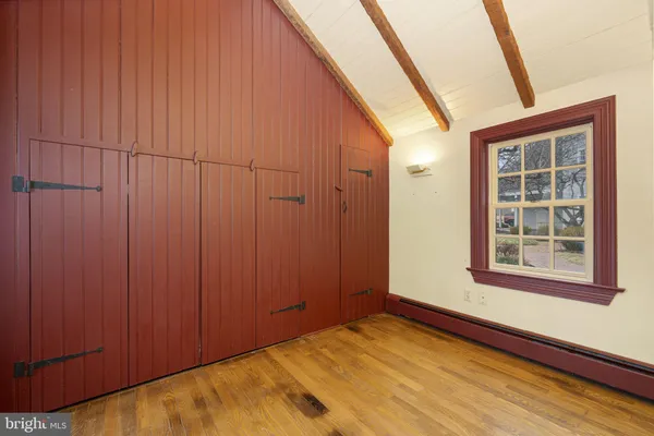 a view of front door and bedroom with wooden floor