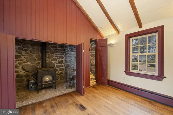 a view of an empty room with wooden floor and a ceiling fan