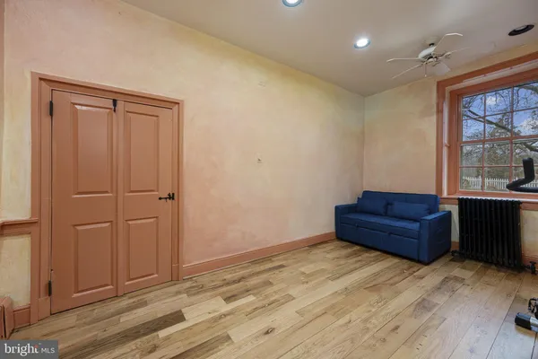 a view of an empty room with bookshelf and a window