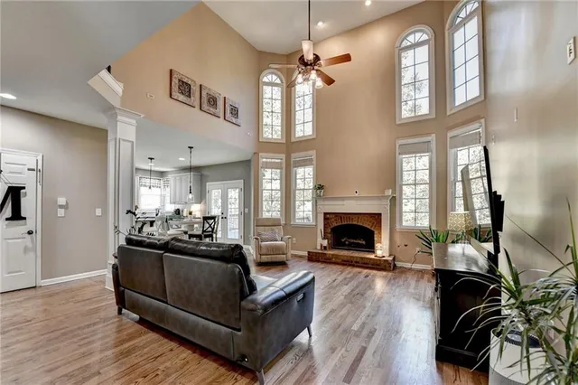 a kitchen with stainless steel appliances a dining table chairs refrigerator and wooden cabinets