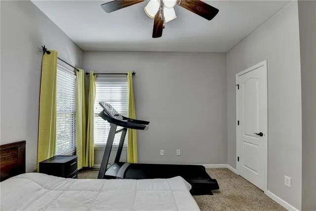 a bedroom with a bed a flat screen tv and a large window