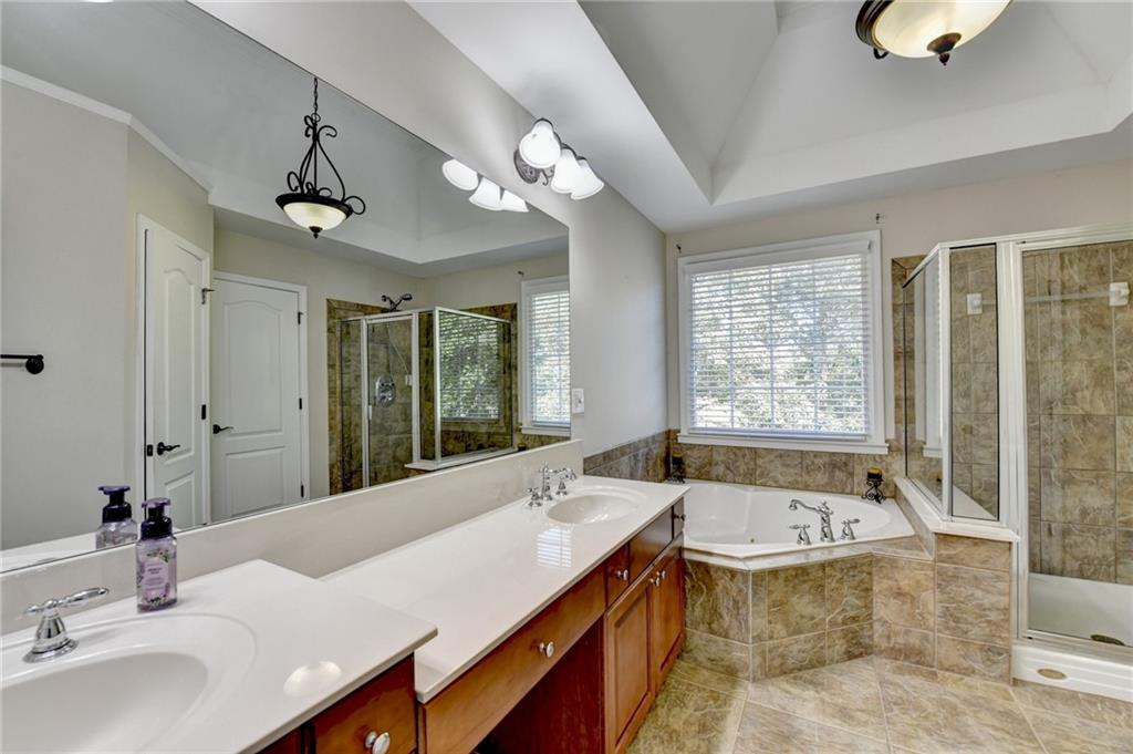 1973 Hamilton Mill Parkway Dacula, GA 30019 - Photo 50 of 105 a spacious bathroom with a granite countertop tub sink and mirror