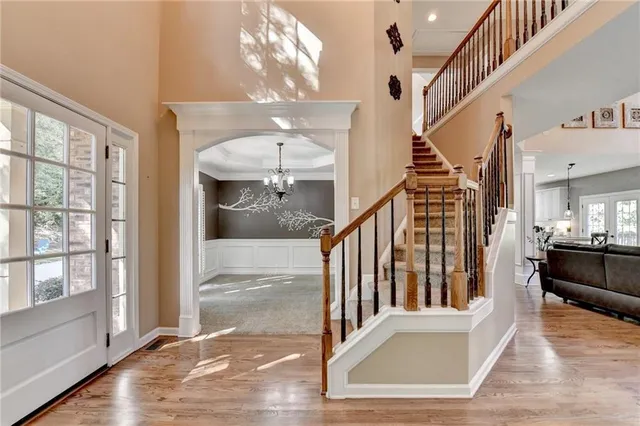 a view of a livingroom with a chandelier curtains and large windows