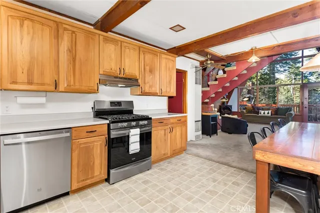 a kitchen with stainless steel appliances granite countertop a stove a sink and a refrigerator