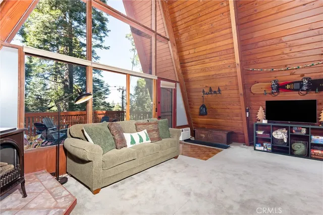 a living room with furniture a flat screen tv and a floor to ceiling window