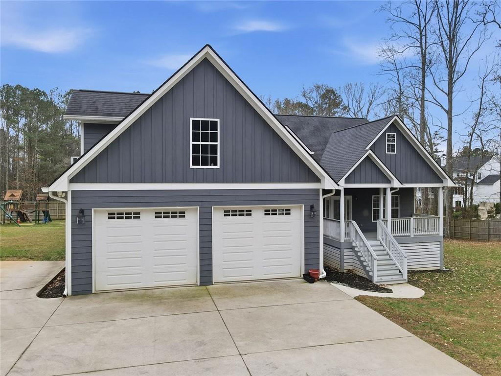 a view of house with wooden fence next to a yard