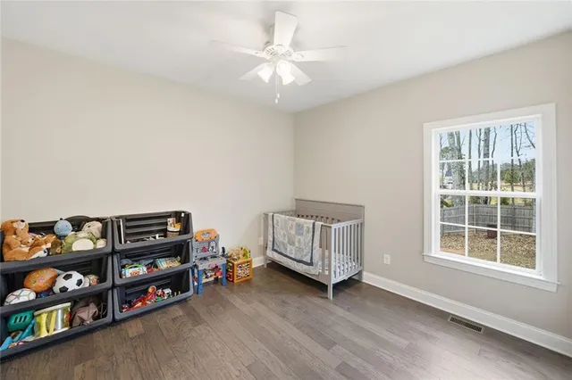 a view of a bedroom with baby crib and a window