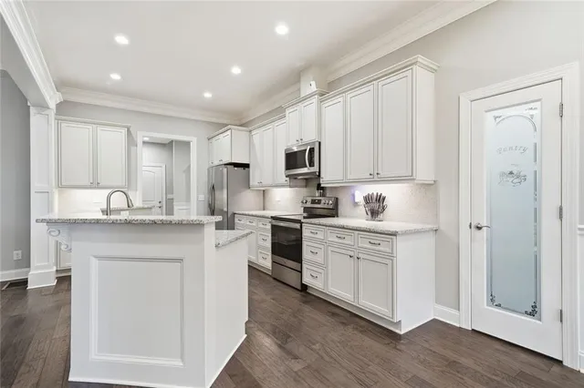 a kitchen with granite countertop white cabinets and white appliances
