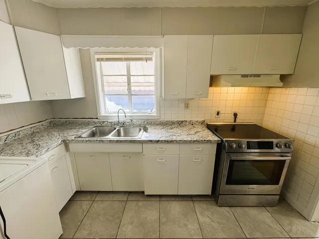 a kitchen with a stove sink and cabinets