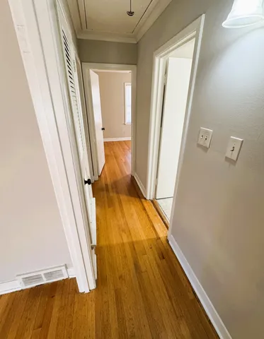 a view of a hallway with wooden floor and staircase