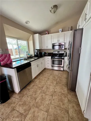 a kitchen with stainless steel appliances granite countertop a stove a sink dishwasher a refrigerator and a oven