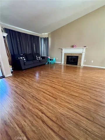 a view of a livingroom with wooden floor and a fireplace