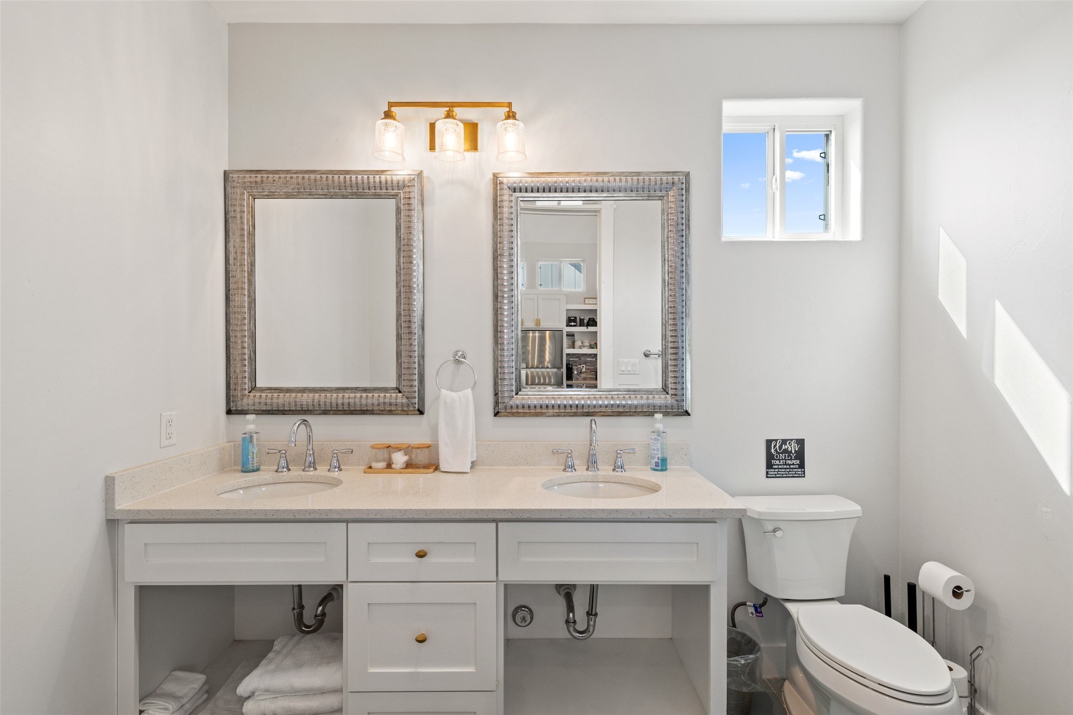 810 Kothmann Road Dripping Springs, TX 78620 - Photo 32 of 40 Gleaming fixtures and natural light elevate this modern dual-sink vanity space.