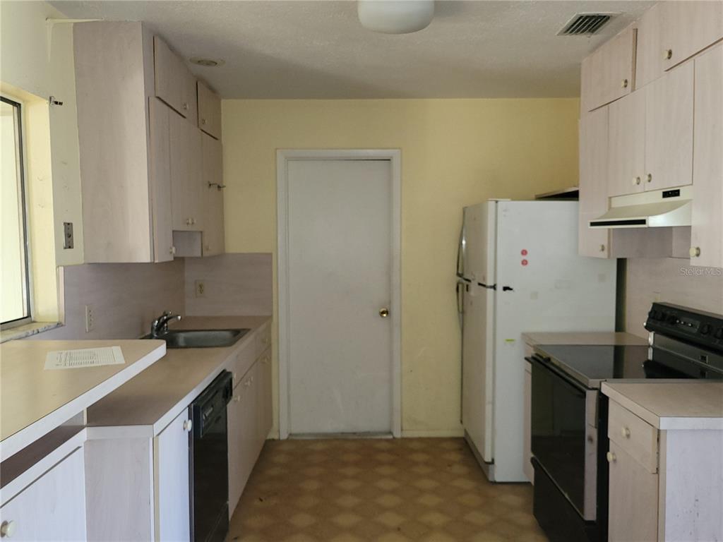 653 Atlas Avenue Northeast Palm Bay, FL 32905 - Photo 19 of 24 a kitchen with a sink stove and refrigerator