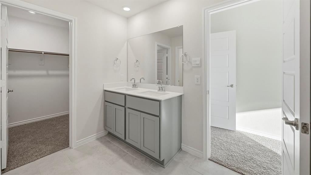 419 Epiphany Lane Lavon, TX 75166 - Photo 21 of 31 Bathroom featuring a double vanity with stone-finish countertop, dual sinks, and light gray cabinetry