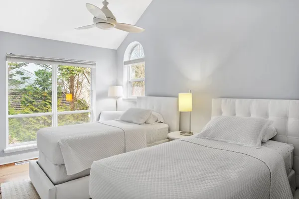 a bedroom with two beds and a large window