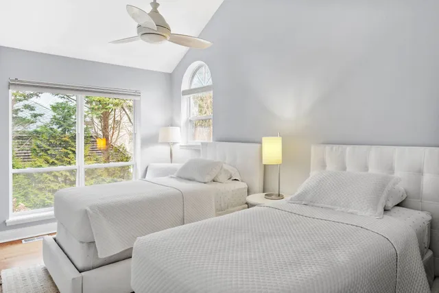 a bedroom with two beds and a large window