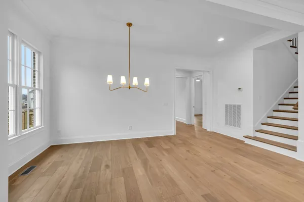 a view of kitchen with white cabinets and wooden floor