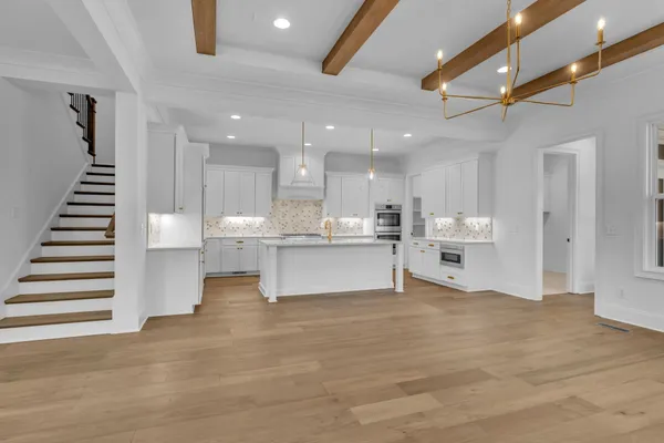 a kitchen with stainless steel appliances granite countertop a sink a stove and a wooden floors