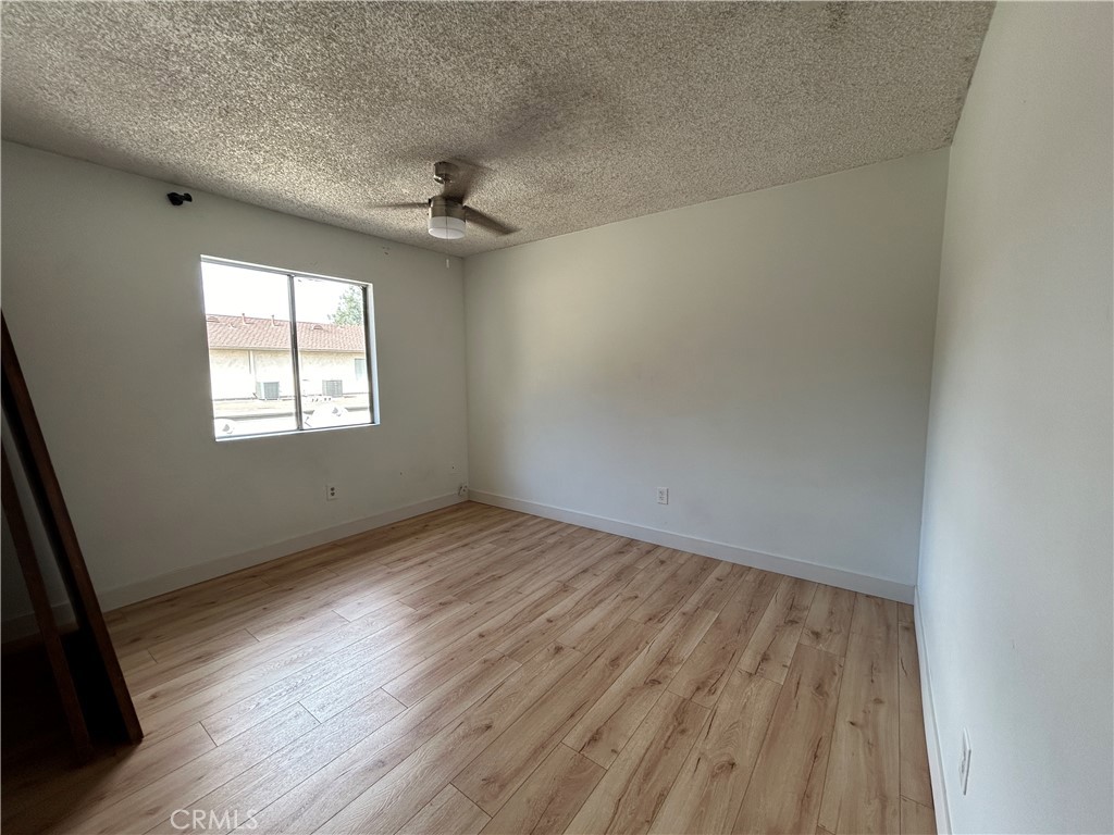 511 D Street Upland, CA 91786 - Photo 16 of 23 an empty room with wooden floor fan and windows
