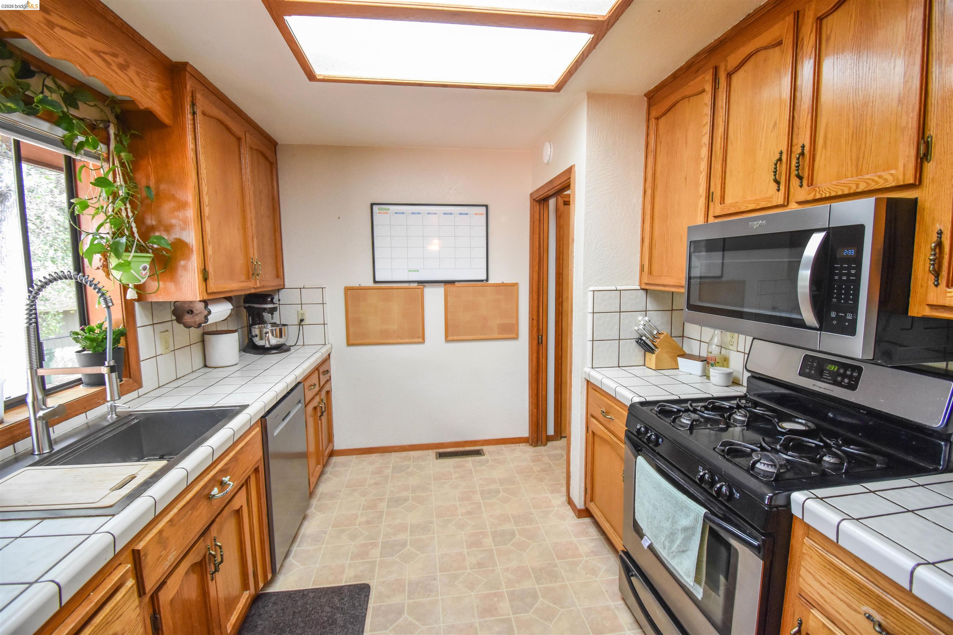 15 Roble Road Sonora, CA 95370 - Photo 15 of 44 Kitchen featuring tile countertops, stainless steel appliances, wood finish cabinetry, and tasteful backsplash