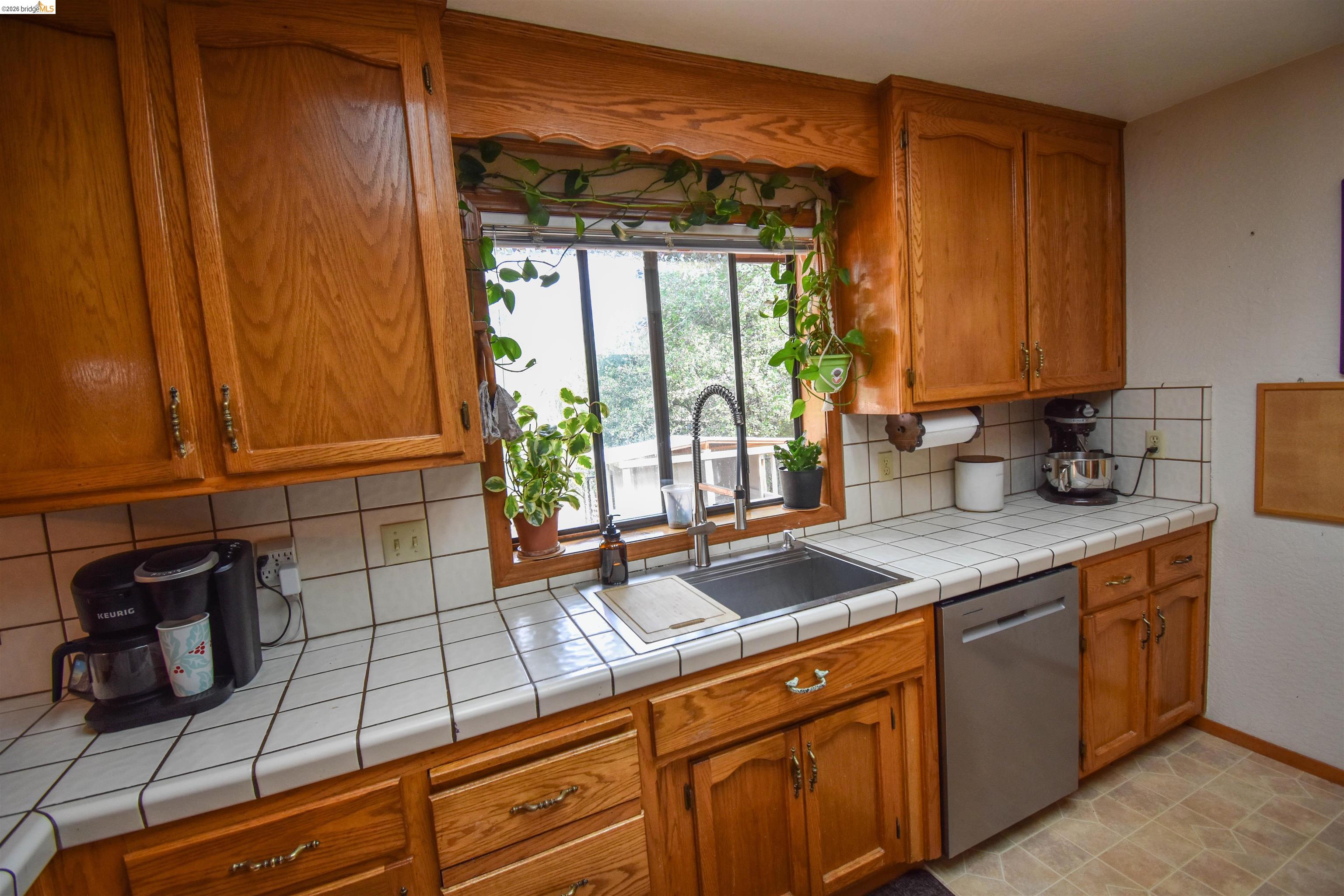 15 Roble Road Sonora, CA 95370 - Photo 16 of 44 Kitchen with wood finish cabinets, tasteful backsplash, dishwasher, and tile counters