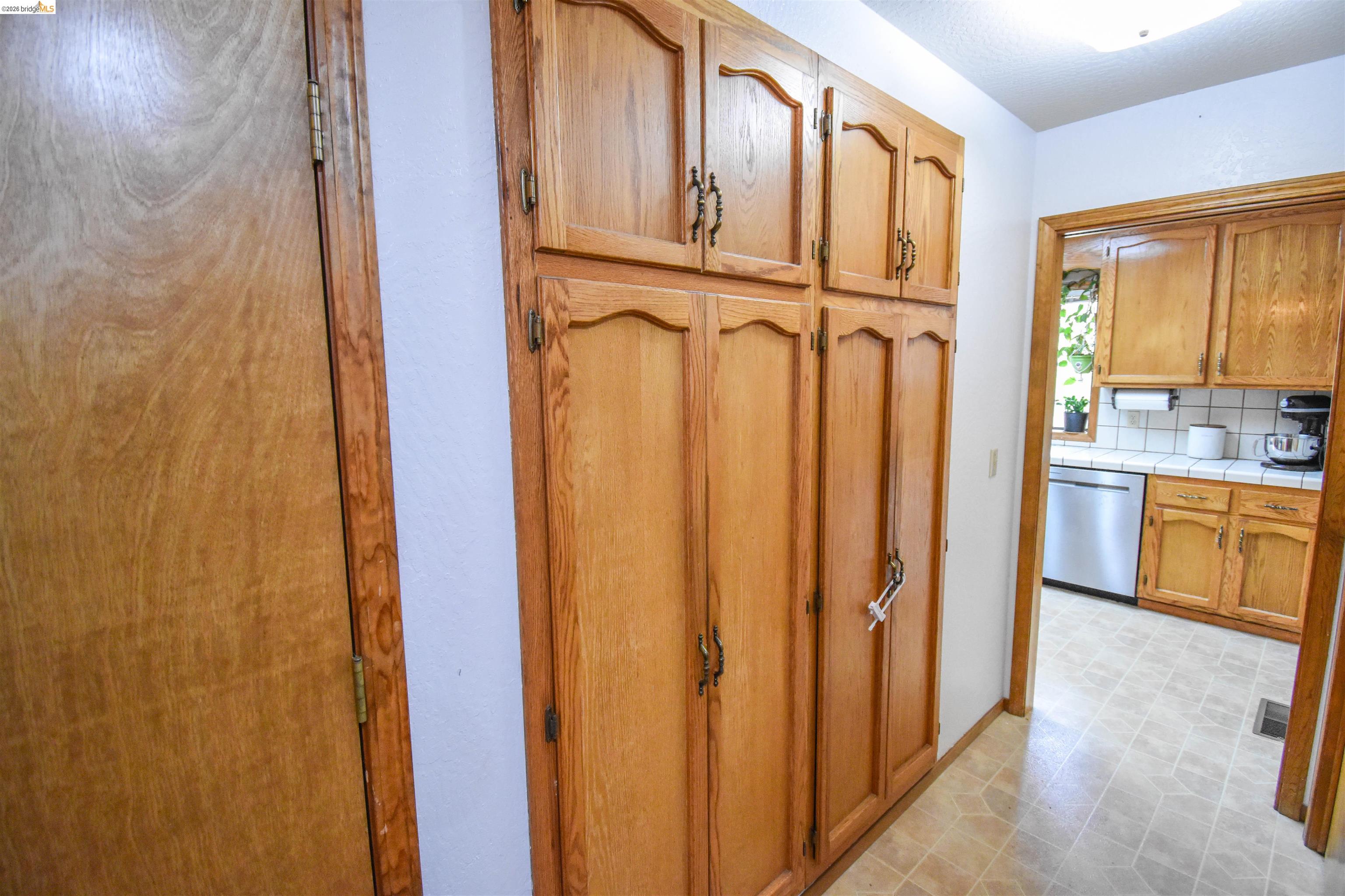 15 Roble Road Sonora, CA 95370 - Photo 18 of 44 Kitchen with stainless steel dishwasher, wood finish cabinets, backsplash, and tile countertops