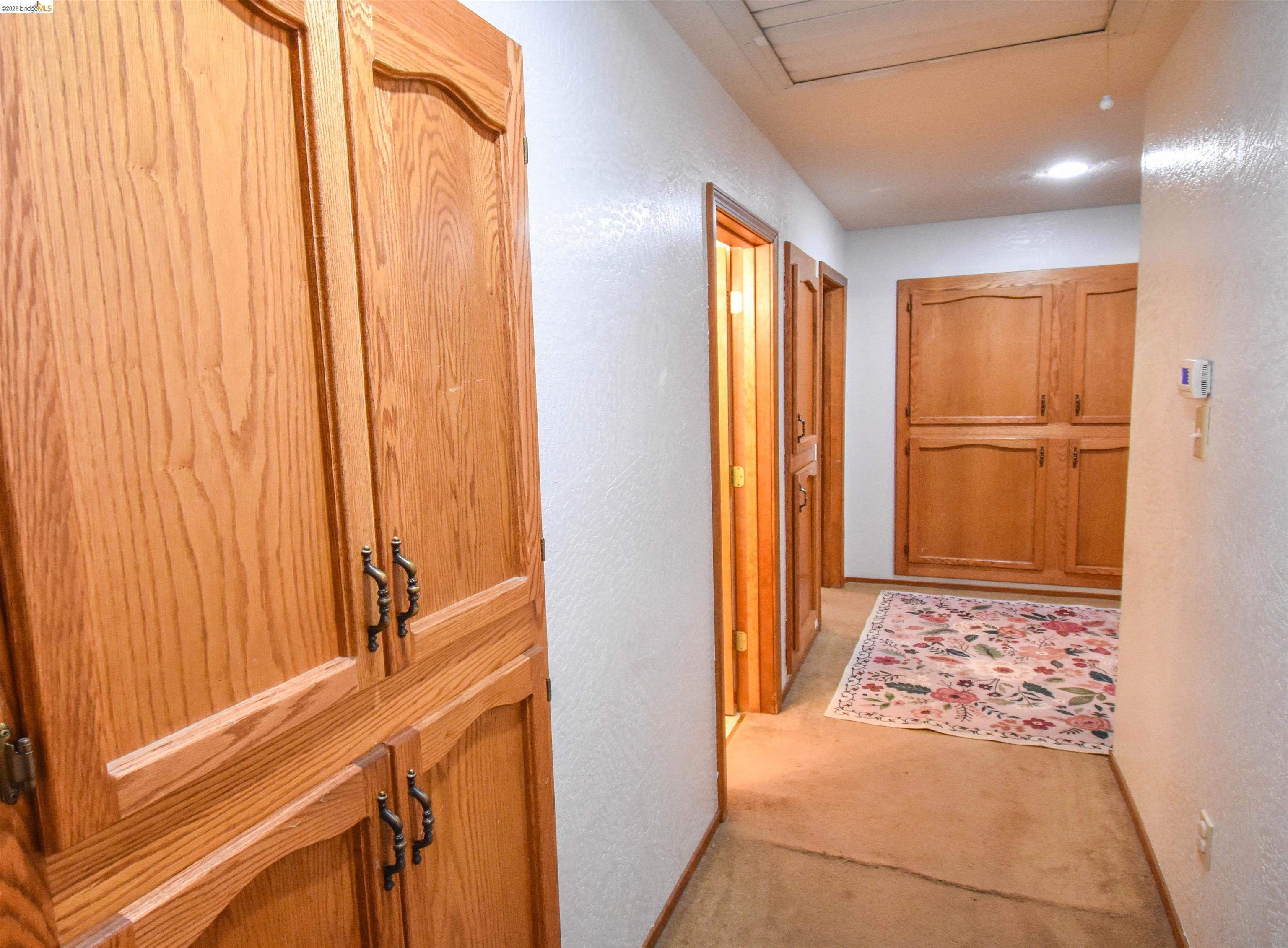 15 Roble Road Sonora, CA 95370 - Photo 19 of 44 Hall with a textured wall, light colored carpet, and cooling unit